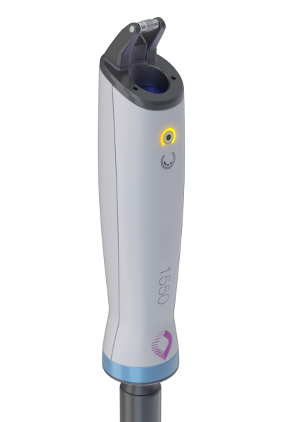 A close-up of a medical device with a 1550 label, a glowing yellow indicator light, a blue base, and a purple logo near the bottom. The device is upright against a plain white background.