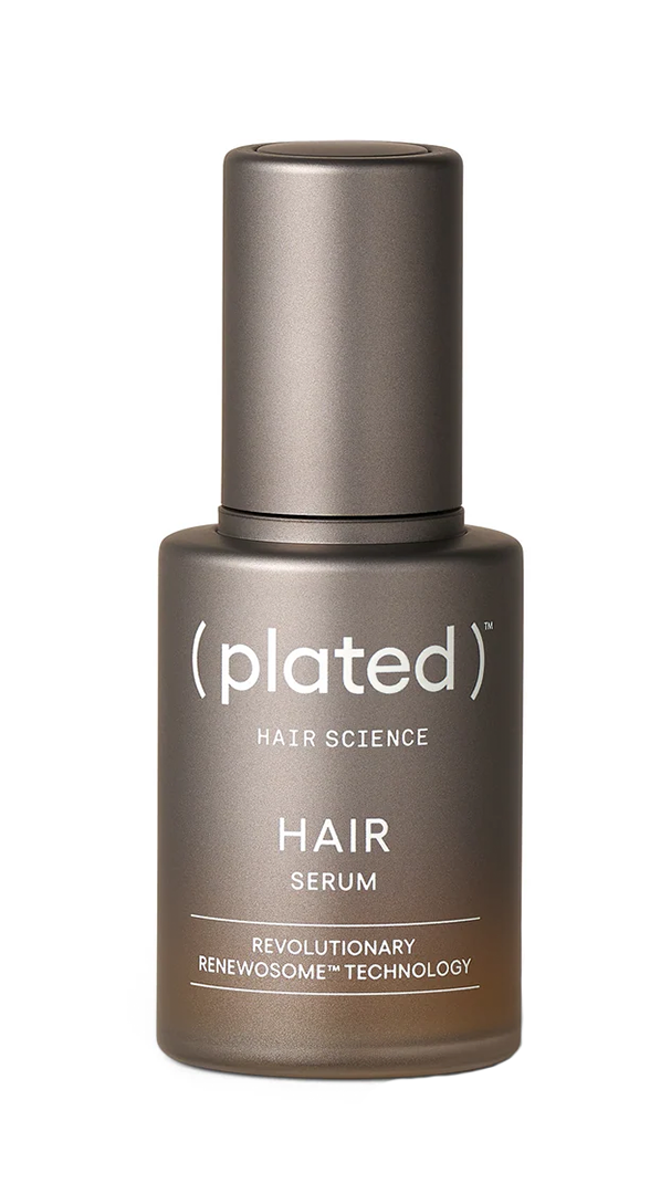 A bottle of Plated HAIR Serum with Revolutionary Renewosome Technology, featuring a sleek, metallic gray design and a pump lid.